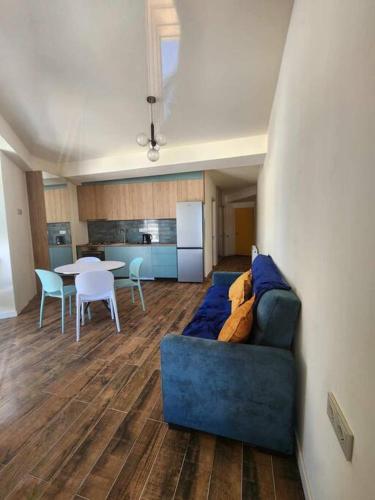 a living room with a blue couch and a table at Cozy Apartment 201A • BMIX • in Bakuriani