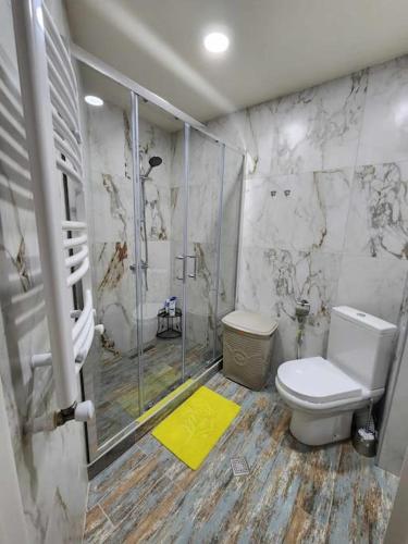 a bathroom with a toilet and a glass shower at Cozy Apartment 201A • BMIX • in Bakuriani
