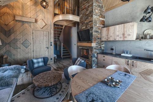 a kitchen with a table and a living room at Pensjonat Orlik Mountain Resort&SPA in Bukowina Tatrzańska