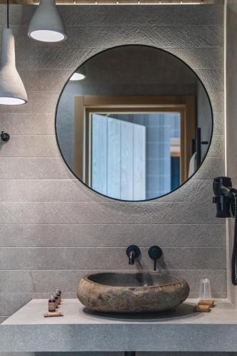 a bathroom with a sink with a round mirror at Pensjonat Orlik Mountain Resort&SPA in Bukowina Tatrzańska