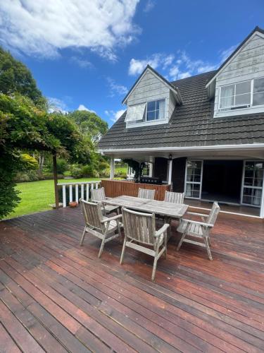 a wooden deck with a table and chairs on a house at Horse Shoe Manor in Paihia