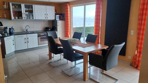 a kitchen with a wooden table and chairs and a window at Ferienhaus direkt am See - a55828 in Blankensee