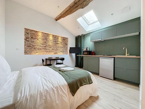une chambre avec un grand lit et une cuisine dans l'établissement [PARENTHESE] Le Toulousain, à Saint-Jory