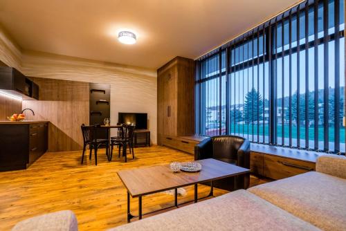 een woonkamer met een tafel en een groot raam bij Rezidencia HONT in Krupina