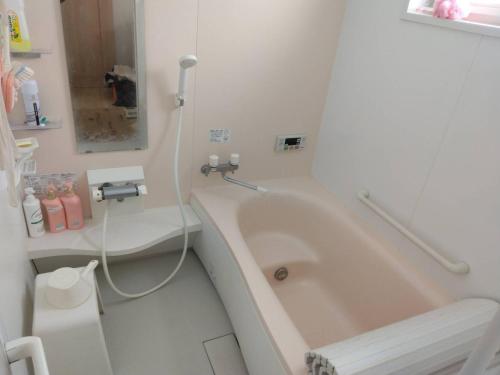 a bathroom with a bath tub and a toilet at 農家民泊せたな牛ハウス in Setana