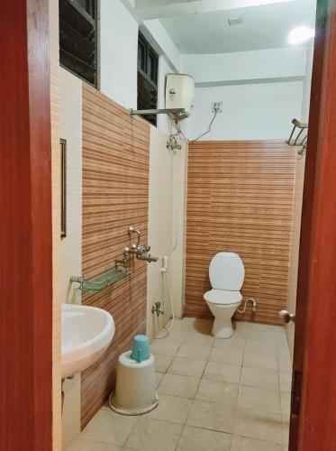 a bathroom with a toilet and a sink at HOTEL SUN CITY in Puri