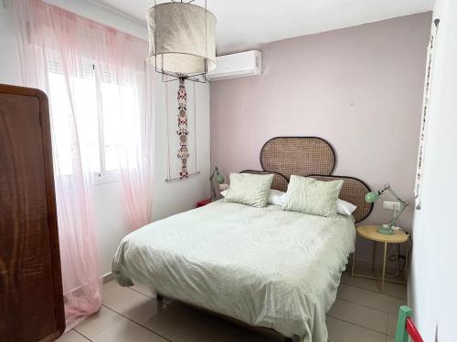 コニル・デ・ラ・フロンテーラにあるTrozo de Luz AP Parking y Terrazaのベッドルーム1室(白いシーツ付きのベッド1台、窓付)