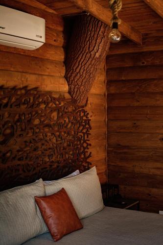 a room with a bed in a log cabin at Boskenvid Hotel - Romantic Treehouses & Skypool in Valle de Guadalupe