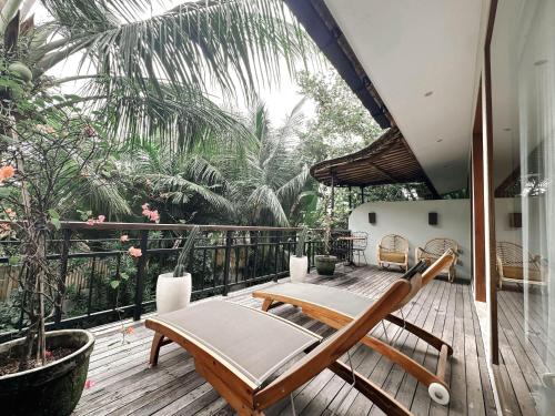 a patio with a table and chairs on a deck at ZIN Canggu Resort & Villas in Canggu