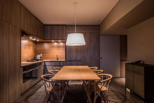 a dining room with a table and chairs in a kitchen at MUWA NISEKO in Kutchan