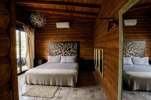 a bedroom with two beds in a room with wooden walls at Boskenvid Hotel - Romantic Treehouses & Skypool in Valle de Guadalupe
