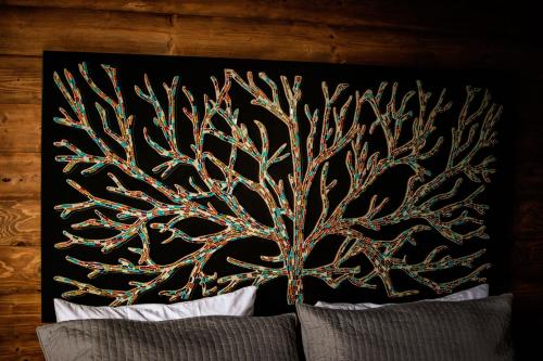 a headboard with a tree design on top of a bed at Boskenvid Hotel - Romantic Treehouses & Skypool in Valle de Guadalupe