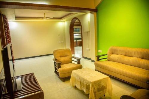 a living room with a couch and chairs and a table at 2BHK Modern Suites in North Goa in Saligao