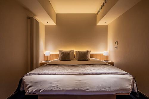 a bedroom with a large bed with two lamps at MUWA NISEKO in Kutchan