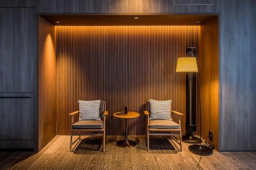 a room with two chairs and a table and a lamp at MUWA NISEKO in Kutchan