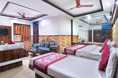a hotel room with two beds and a chair at Hotel Glow Inn Paharganj-3 Mins Walk From New Delhi Railway Station in New Delhi