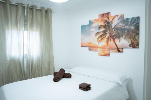 1 dormitorio con 1 cama blanca y 2 cuadros en la pared en City town apartment, en Santander
