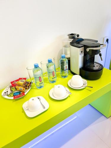 a table with plates and a coffee maker on it at Christina Hotel in Bucharest