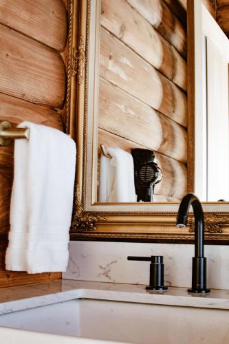 a bathroom with a sink and a mirror and towels at Boskenvid Hotel - Romantic Treehouses & Skypool in Valle de Guadalupe
