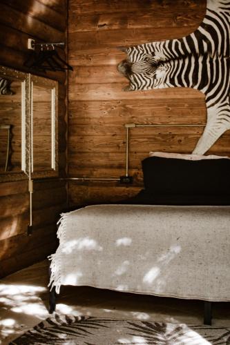 a zebra standing on a bed in a room at Boskenvid Hotel - Romantic Treehouses & Skypool in Valle de Guadalupe
