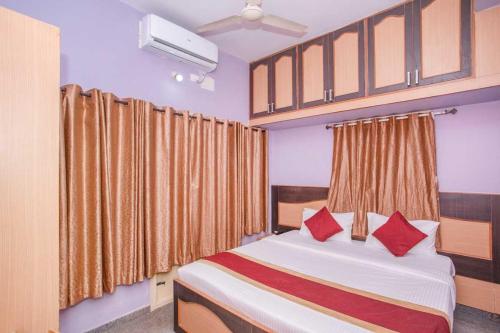 a bedroom with a bed with red pillows at Collection O Blossom Suites in Bangalore