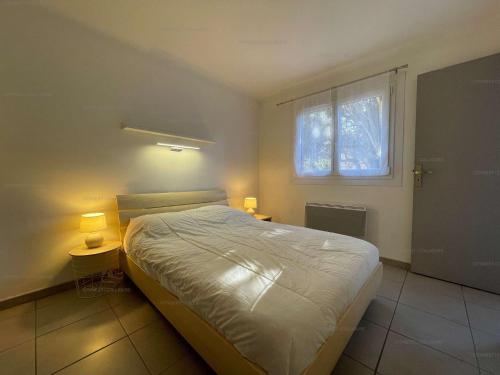 een slaapkamer met een bed en een raam met verlichting bij 4VSE-VER4 - Très bel appartement idéalement situé avec parking privé in Collioure