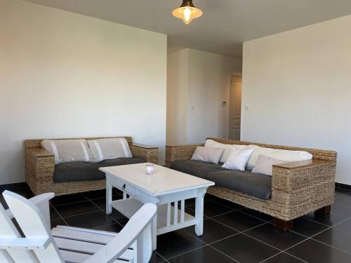 un salon avec deux canapés et une table dans l'établissement 311 - Maison récente à quelques pas de la magnifique plage de l'Anse du Croc, à Fréhel