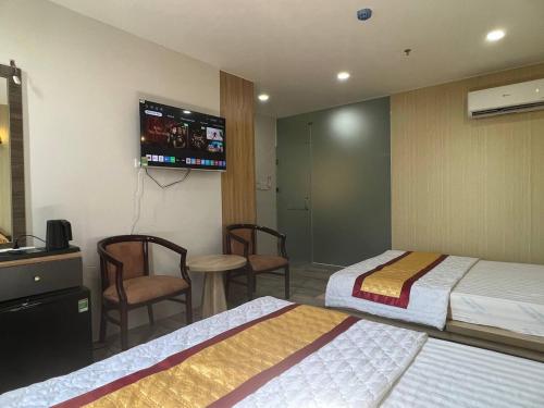 a hotel room with two beds and a flat screen tv at Hotel Stylish Tân Khai in Hớn Quản