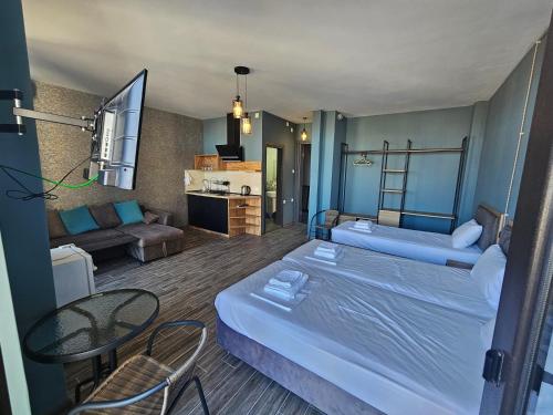 um quarto de hotel com duas camas e uma sala de estar em Casa Del Mar em Kvariati