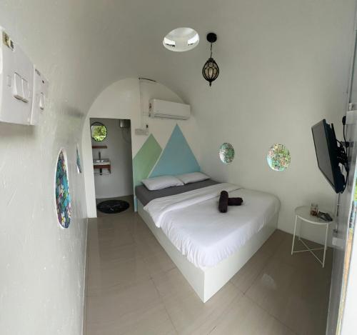 a bedroom with a white bed and a tv at Qowiy Village Langat in Hulu Langat