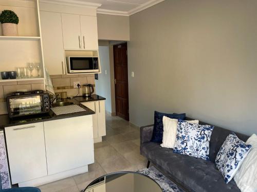 een woonkamer met een bank en een keuken bij 642 on Vincent in Pretoria