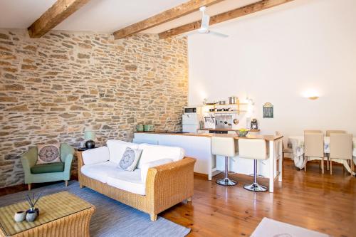 Il dispose d'une cuisine et d'un salon avec un mur en briques. dans l'établissement La Maison Des Vignes - Gite Olivier - Luxury Gite with Air Conditioning, à Tourouzelle