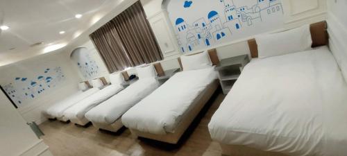 a row of beds in a room with white sheets at 柜富賓王旅店-台北館 Giant Rich King Plaza Hotel in Taipei