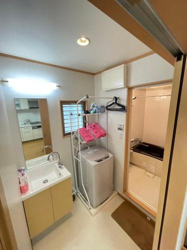 a small bathroom with a sink and a washing machine at 糖果屋 in Osaka