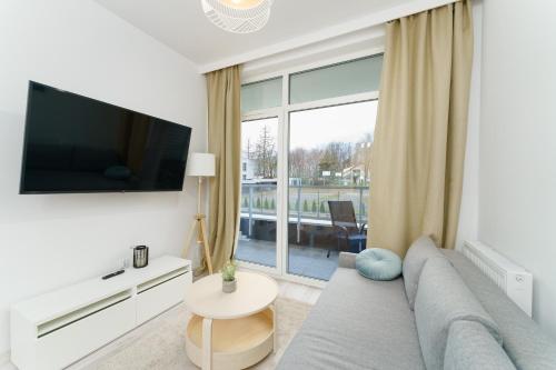 Μια τηλεόραση ή/και κέντρο ψυχαγωγίας στο Apartament Przystań z Basenem Letnim by HolidaySun