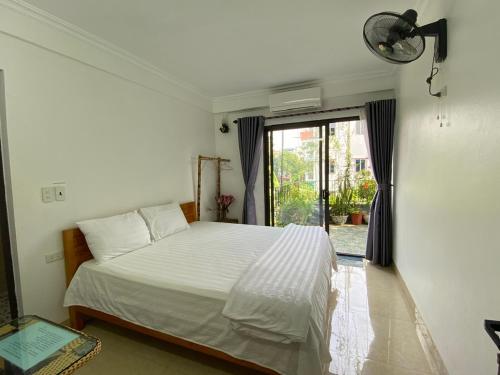 Un dormitorio con una cama blanca y una ventana. en Mr Thông Homestay, en Ninh Binh