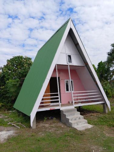 uma pequena casa rosa e branca com um telhado triangular em Wood Town Resort em Kharem