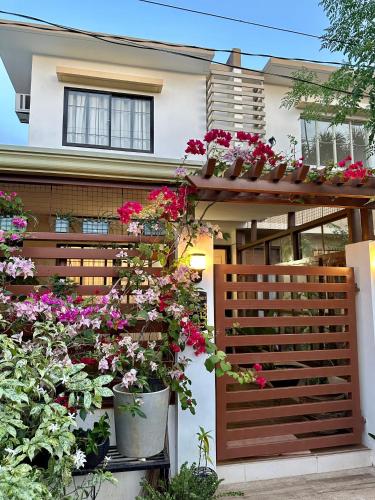 a house with potted flowers on a wooden fence at Casa Privado- 2 Bedroom House Near the Airport in Puerto Princesa City