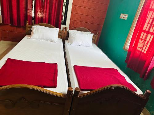 two beds sitting next to each other in a room at shree katyayani residency in Gokarna