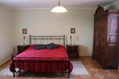 CasteggioにあるCascina Angelinaのベッドルーム1室(赤いベッド1台、ナイトスタンド2台付)