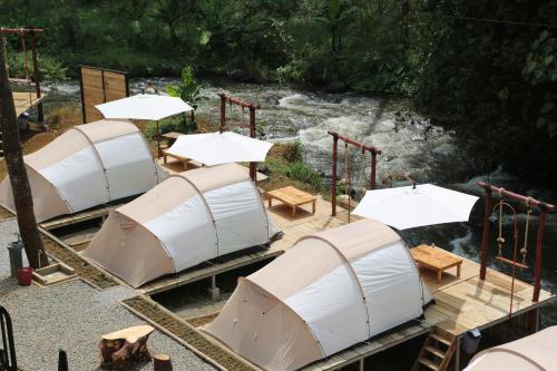 an overhead view of a group of tents next to a river at SoraCai Riverside Campsite in Palayangan