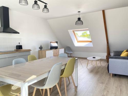 une table à manger et des chaises dans un salon dans l'établissement 303 - Appartement 3 pièces très lumineux en plein cœur de Fréhel, à Fréhel