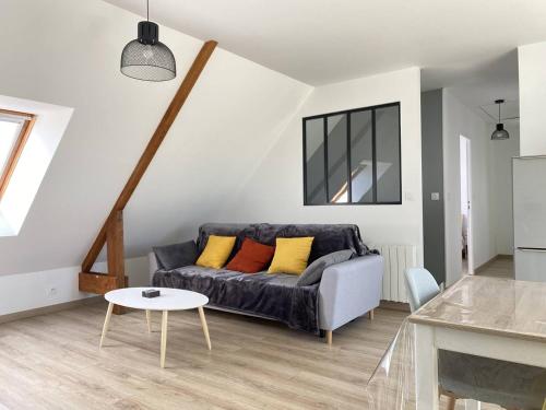 un soggiorno con un divano e un tavolo di 303 - Appartement 3 pièces très lumineux en plein cœur de Fréhel a Fréhel