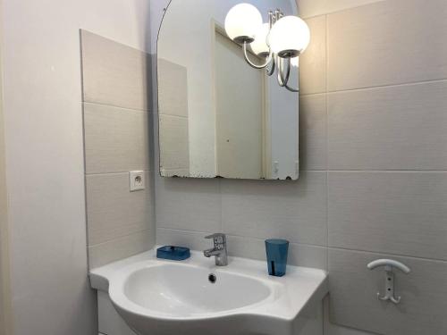 a white bathroom with a sink and a mirror at 359 - Appartement T3, à deux pas de la plage l'Anse du Croc et de sa vue sur le Cap Fréhel in Frehel