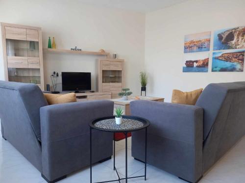 Sala de estar con 2 sofás y mesa en Nr41 Holiday Apartment - Spacious & Bright 3 Bedroom, 2 Bathroom Apartment - Marsaxlokk Malta, en Marsaxlokk