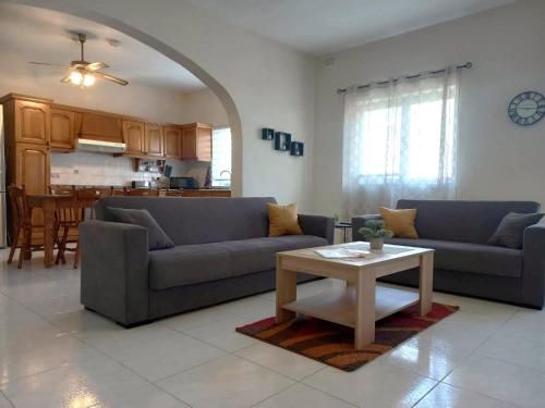 Sala de estar con 2 sofás y mesa en Nr41 Holiday Apartment - Spacious & Bright 3 Bedroom, 2 Bathroom Apartment - Marsaxlokk Malta, en Marsaxlokk