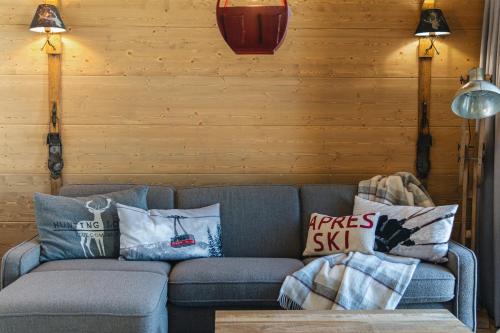 a living room with a couch with pillows on it at Pensjonat Orlik Mountain Resort&SPA in Bukowina Tatrzańska