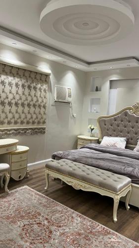 a bedroom with a large bed and a desk at شقة بموقع مميز قريبة من الحرم في قلب المدينة وبجانبها جميع الخدمات in Al Madinah