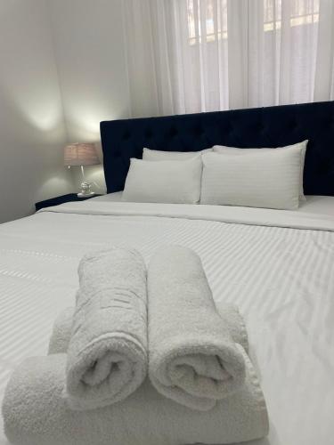 a white bed with two towels on it at Stan na dan Sunce in Sremska Kamenica