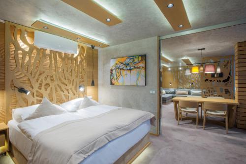 布拉格Wellness Hotel Step - Czech Leading Hotels的一间卧室配有一张床和一张书桌,还有一间用餐室